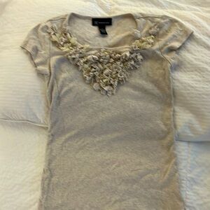 Oatmeal women’s T-shirt with interesting detail at the neck.
